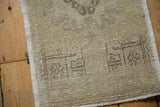 Vintage distressed Oushak rug mat corner showing even wear to knot heads and secured side.