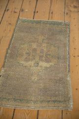 Distressed Oushak rug's worn pile texture, showing faint foundation and muted green-mauve tones.