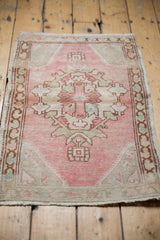Soft pink and ivory distressed Oushak rug showing Rococo floral detail and abrashes.