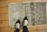 Distressed vintage Turkish Oushak rug detail, highlighting pale gold, charcoal stepped medallion and abrashes.