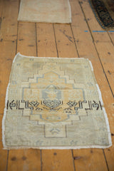 Distressed Oushak rug corner, showing stepped geometric patterns, pale dusty gold, and abrashes.