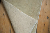 Hand-knotted reverse and distressed pale ivory-beige pile of the vintage Oushak rug.