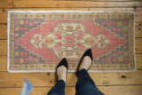 Distressed vintage Oushak rug with blush medallion, slate grey floral spandrels, and worn texture.