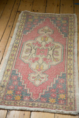 Distressed Oushak rug's faded blush and grey field with gold seed border and floral motifs.