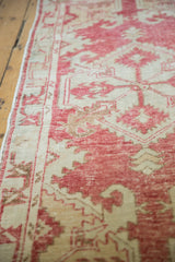 Distressed texture of vintage Oushak runner, with faded cochineal red and ivory pattern.