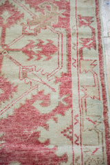 Distressed vintage Oushak runner with faded cochineal red serrated leaves on antique ivory.