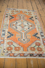 Vintage distressed Oushak rug, faded orange-red field, ivory medallion, and geometric motifs.