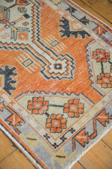 Distressed Oushak rug with faded orange-red, ivory halved palmette motifs and visible wear.