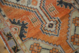 Faded orange-red, ivory, and charcoal geometric patterns with distressed texture.