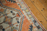 Distressed Oushak runner showing faded rust, ivory, and charcoal geometric border with faint foundation.
