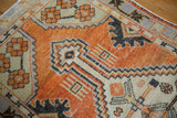 Distressed Oushak rug close-up: worn texture, faded orange-rust, ivory, charcoal patterns.