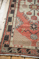 Vintage Distressed Oushak rug corner with charcoal geometric border and worn cherry red field.