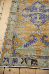 Distressed Oushak rug pile texture with dusty gold, royal blue, seafoam green.