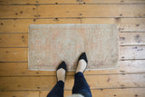 Distressed Oushak rug's faded ivory and blush red pile with subtle traditional patterns.
