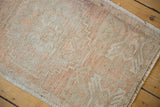 Distressed vintage Oushak rug texture, highlighting faded blush red and low pile.
