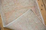 Faded ivory pile with even wear on a distressed vintage Oushak rug's woven foundation.