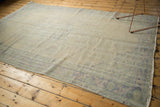 Faded Rococo border and distressed texture on the corner of this vintage Oushak carpet.