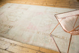 Textured low pile and soft pastel motifs on a vintage distressed Oushak rug's edge.