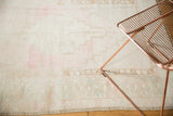 Distressed Oushak rug's low pile showing pale pink, blush, and soft blue abrash.