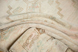 Distressed low pile texture showing pale pink, powder blue, and ivory tones.