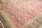 Distressed vintage Sivas carpet corner: blush Herati field, worn beige floral border, and fringe.