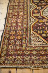 Cherry red, saffron yellow, ivory geometric borders of a vintage Caucasian rug corner, light tatter evident.