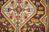 Caucasian rug's geometric bird pattern in ivory, red, yellow, charcoal, with visible wear.