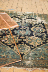 Worn antique Malayer rug with exposed foundation, navy, teal, ivory Herati motifs.