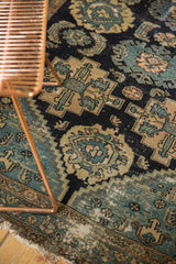 Antique Malayer fragment with threadbare Herati and palmette motifs in navy, dusty teal, and ivory.