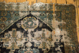 Detail of hard wear, threadbare pile, and frayed perimeter on antique Malayer rug fragment.