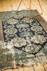 Hard wear and exposed foundation on an antique Malayer fragment rug, with navy and teal palmettes.