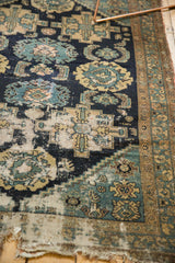 Antique Malayer rug detail: threadbare, holed, tattered edge, navy blue palmette and Herati motifs.