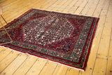 Corner detail of the vintage Bibikabad rug with cherry red border and Herati design.