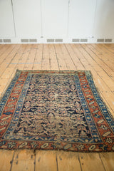 Antique Kurdish rug corner showcasing Herati motif, madder red border, and tattered ends.