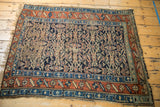 Antique Kurdish rug corner detail: madder root red main border, meandering minor border, tattered end.