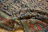 Textured pile, madder root red main border, and tattered fringe of an antique Kurdish rug.