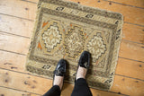 Antique Caucasian rug with triple gul design shown to scale on a wooden floor.