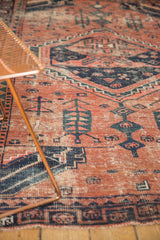 Close-up of vintage West Persian rug showing brick red and navy blue germinating tree motifs.