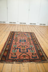 Vintage Lilihan rug end, finned floral motif in dusty blush and indigo, showing 5-inch split.