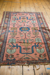 Vintage Lilihan rug with tattered fringe and lower geometric pattern in blush, indigo, and green.