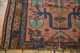 Vintage Lilihan rug corner shows finned floral motifs, indigo border, and hard tatter.