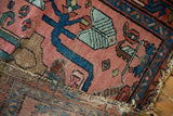 Vintage Lilihan rug's tattered end with loss, showing blush field and indigo blue motifs.