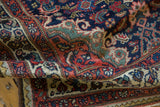 Vintage Tajabad rug's folded low pile, showcasing navy, cherry, cream Rococo motifs.