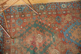 Textured antique Caucasian rug field with red, teal, blue rams horn motifs.