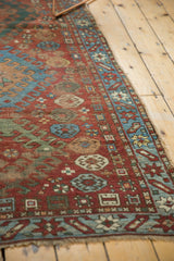 Geometric sky blue and red border of an antique Caucasian rug, showing pinwheel motifs.