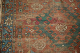 Antique Caucasian rug border detail with geometric hook motifs in red, sky blue, and copper green.