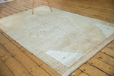 Stepped corner spandrels, floral border, and worn texture on a distressed Oushak rug.