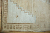 Vintage distressed Oushak rug corner, showing stepped spandrel and geometric brown border.