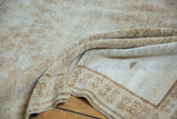 Worn texture and pale coffee brown tones of the distressed Vintage Oushak rug.