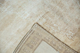 Distressed Oushak rug corner revealing pale coffee pile, faint foundation, and woven reverse.